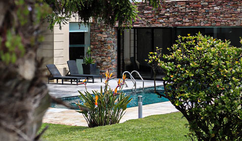 Hotel con piscina y jardín.